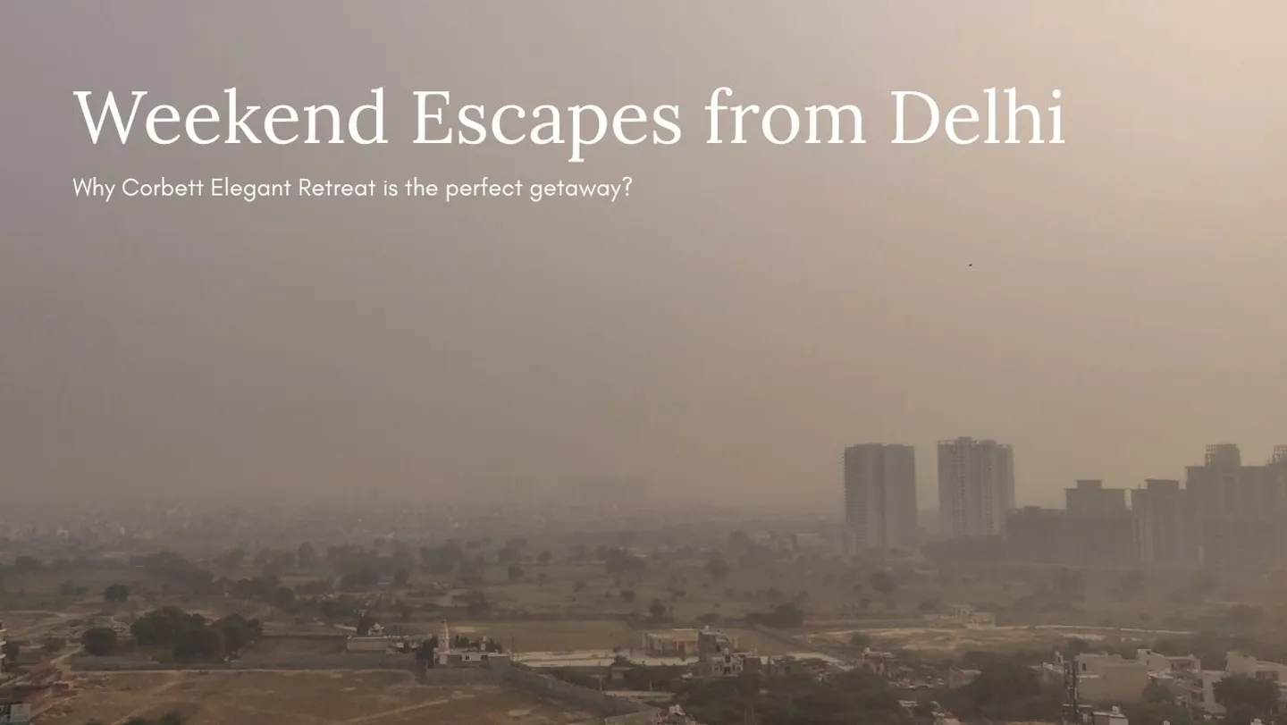 A hazy aerial view of Delhi's cityscape with high-rise buildings in the background and a sprawling residential area in the foreground, evoking a sense of urban hustle and the need for a serene weekend escape to Corbett Elegant Retreat.